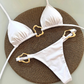 White bikini with gold straps on a woven mat